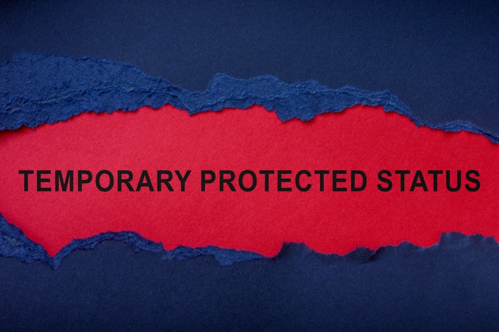 Temporary protected status inscription on red sheet and a torn piece of paper.