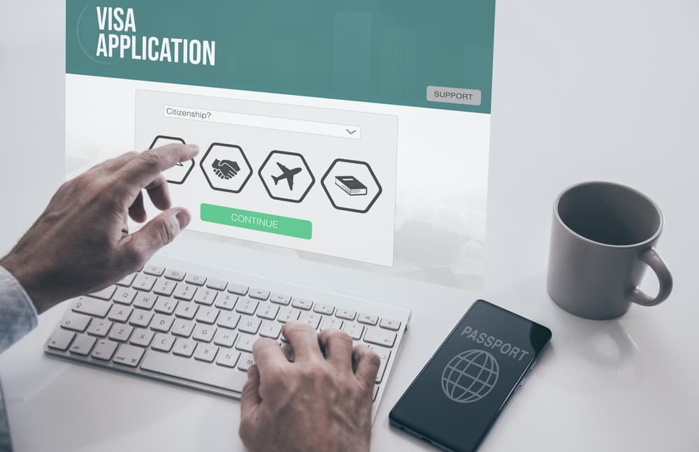 Man filling visa application form on virtual laptop. Work recruitment, travel, immigration
